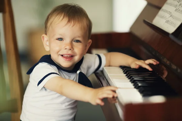 Mały chłopiec gra na pianinie — Zdjęcie stockowe