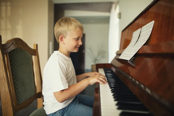 Malý chlapec hraje na klavír — Stock fotografie