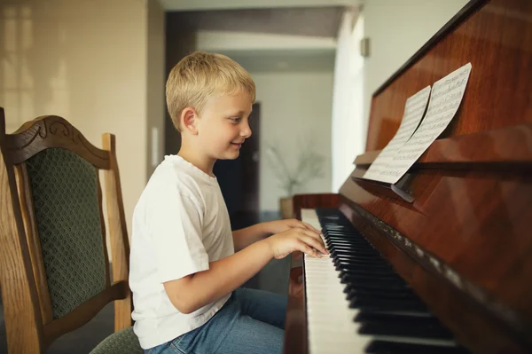 Menino toca piano — Fotografia de Stock