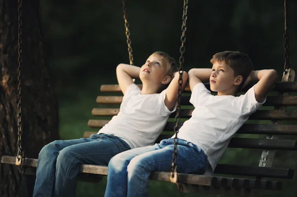 Little boys riding on a swing — Stock Photo, Image