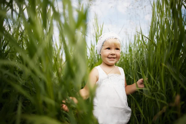 Cute dziewczynka w wysokiej trawie — Zdjęcie stockowe