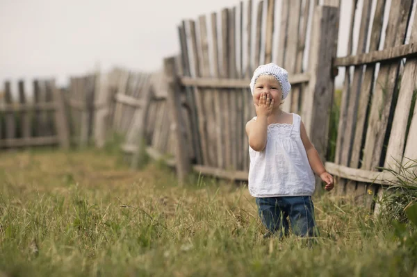 Petite fille et clôture en bois — Photo