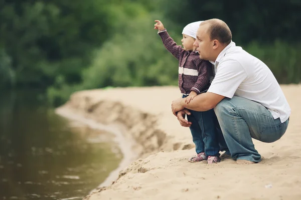 Счастливый отец и его дочь на берегу реки — стоковое фото