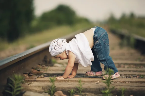 Liten flicka spelar på järnvägen — Stockfoto