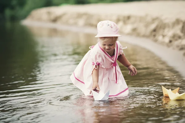 Bambina gioca con barche di carta — Foto Stock