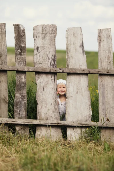 Little girl and wooden fence — Stock Photo, Image