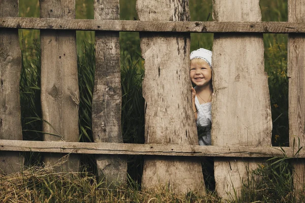 Little girl and wooden fence — Stock Photo, Image