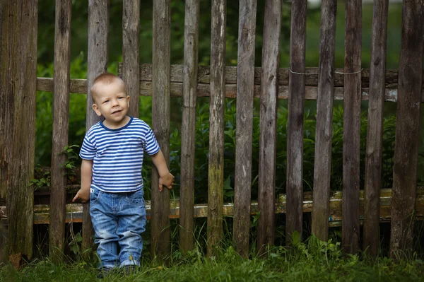 Маленький смішний хлопчик з парканом — стокове фото