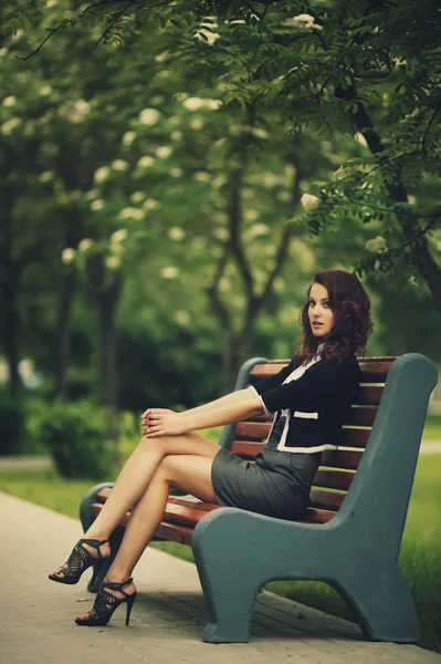 Jeune belle fille assise sur le banc — Photo