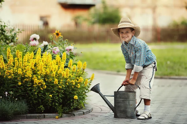 Liten pojke vattning blommor — Stockfoto