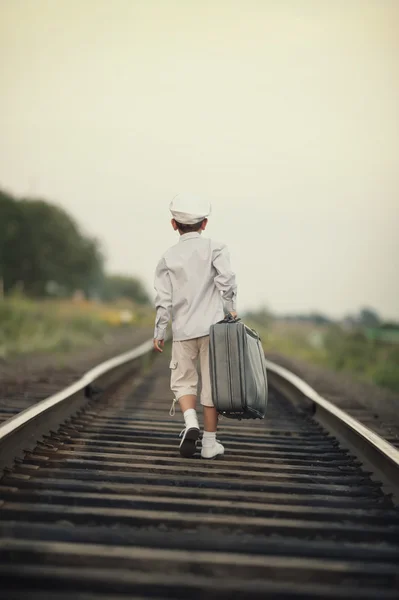 Хлопчик з валізою на залізниці — стокове фото