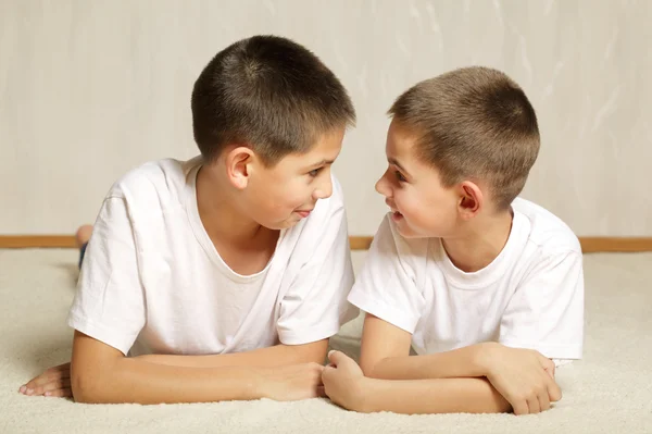 Alegres hermanos acostados juntos — Foto de Stock