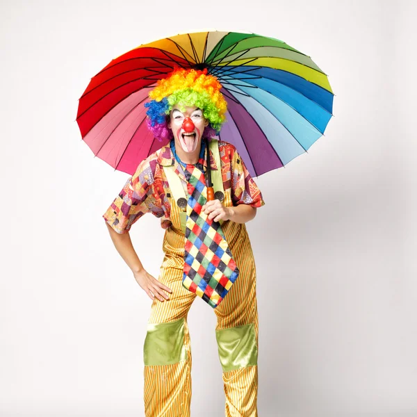 Palhaço engraçado com guarda-chuva colorido — Fotografia de Stock