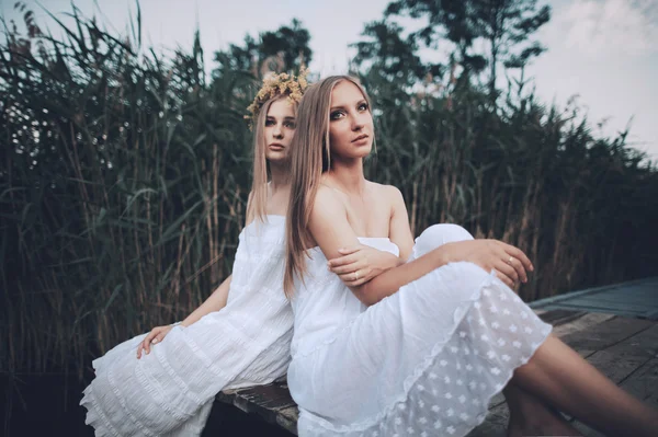 Duas meninas na costa no cais — Fotografia de Stock