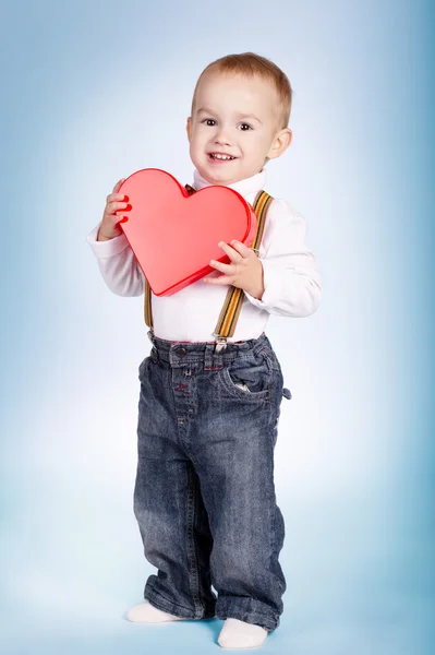 Niño feliz sostiene el corazón en las manos — Foto de Stock