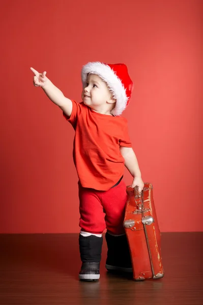 Ładny chłopczyk z czerwoną walizkę — Zdjęcie stockowe