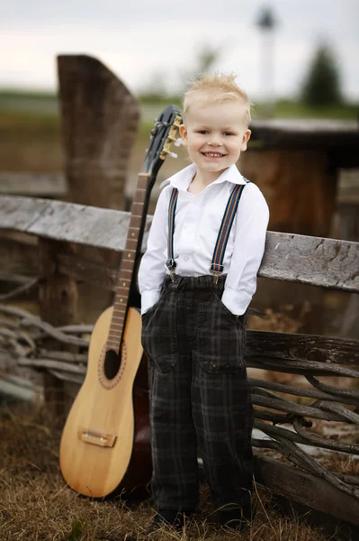 Милый маленький мальчик с гитарой — стоковое фото
