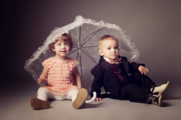 Petit garçon drôle et fille sous parapluie — Photo