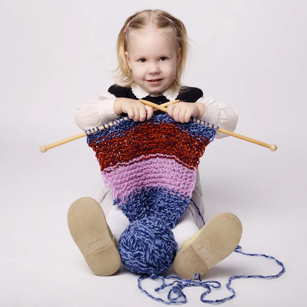 Little girl knitting scarf — Stock Photo, Image