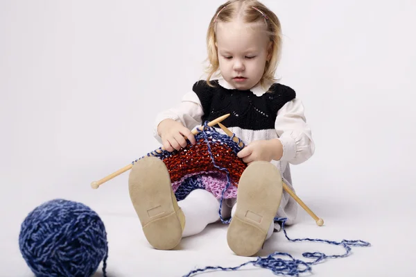 Little girl knitting scarf — Stock Photo, Image