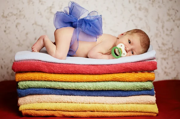 Newborn baby lying on colorful towels — Stock Photo, Image