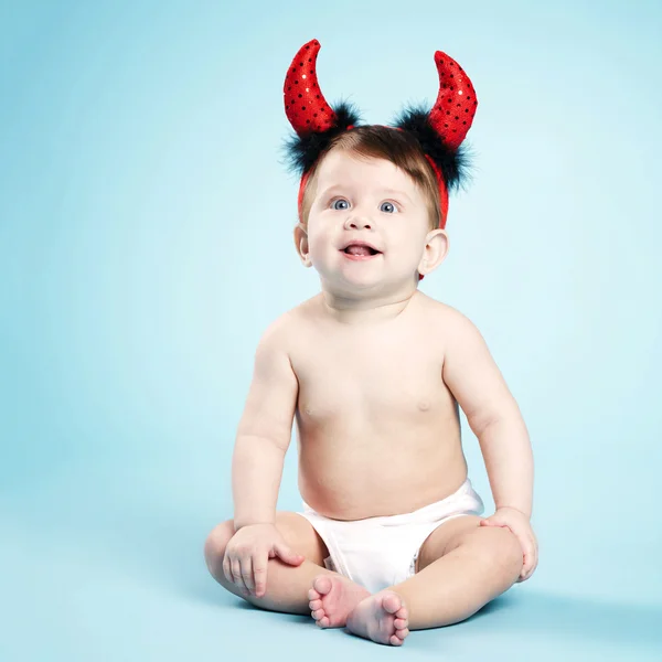Copil cu coarne de diavol pe fundal albastru — Fotografie, imagine de stoc