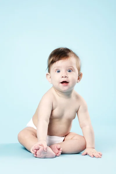 Bebê feliz no fundo azul — Fotografia de Stock