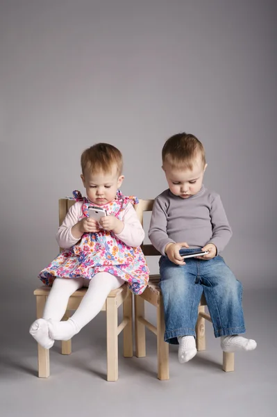 Garçon et fille jouer avec les téléphones mobiles — Photo