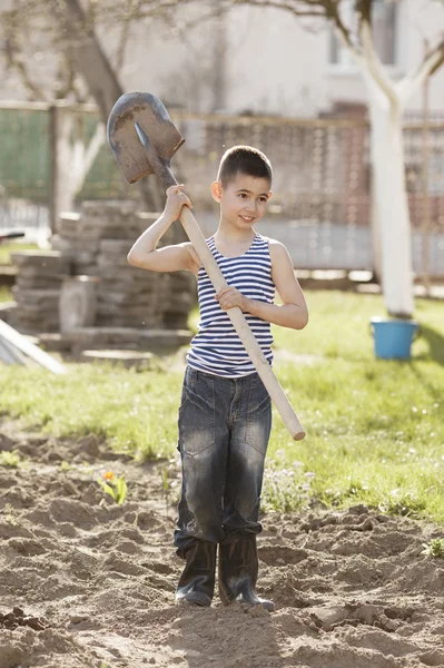 Niño feliz trabajando con la pala en el jardín — Foto de Stock