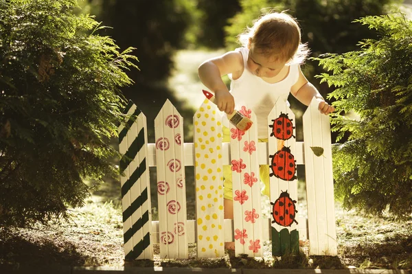 小さな女の子塗料フェンス — ストック写真