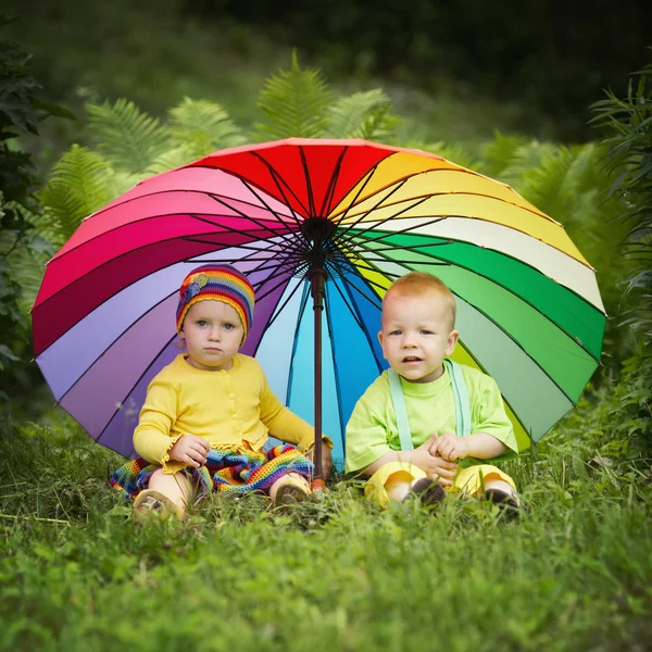 Little children under colorful umbrella — Stock Photo, Image