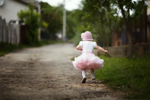 Lilla flickan i klänning kör bort — Stockfoto