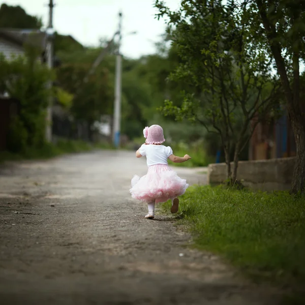 Маленькая девочка в платье убегает — стоковое фото