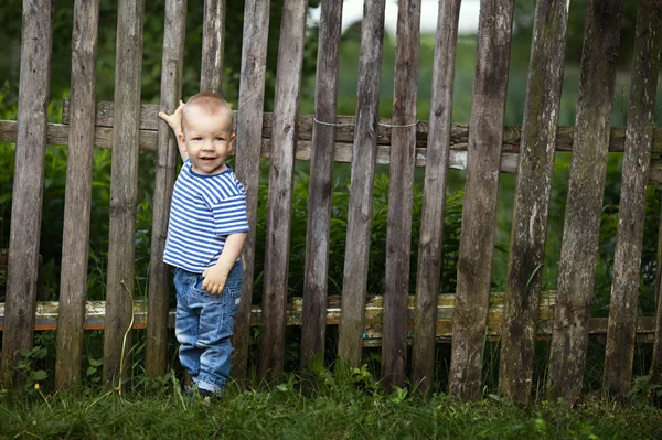 屋外のフェンスと小さな男の子 — ストック写真