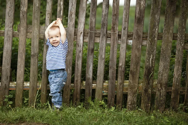 Mały chłopiec z ogrodzenia na zewnątrz — Zdjęcie stockowe