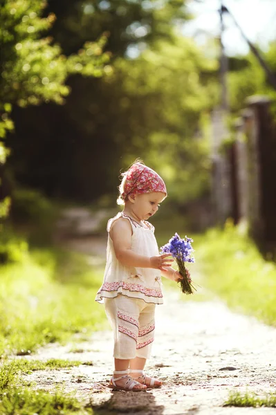 Kleines Mädchen mit Blumen — Stockfoto