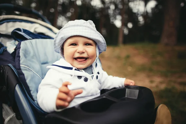 Funny baby porträtt i barnvagn — Stockfoto