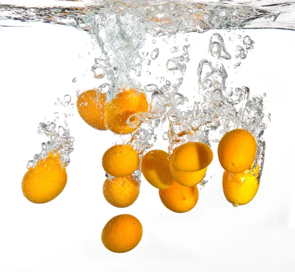 Маленькі апельсини падають у воду — стокове фото