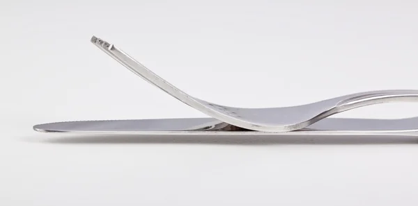Vue latérale de la fourchette et du couteau l'un sur l'autre — Photo