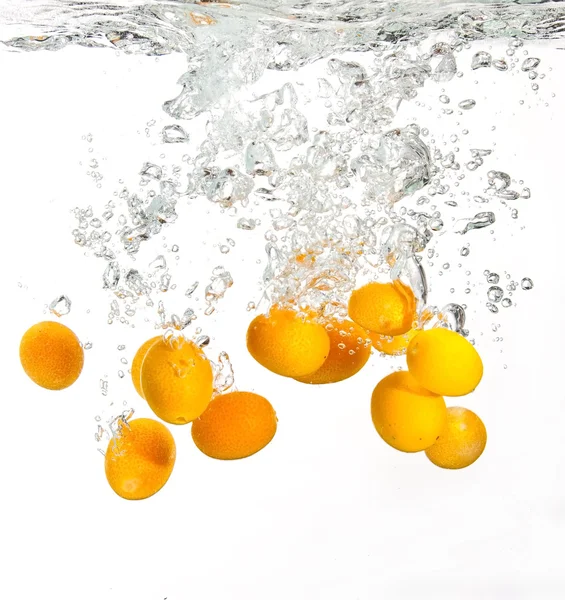 Laranjas amarelas caindo na água — Fotografia de Stock
