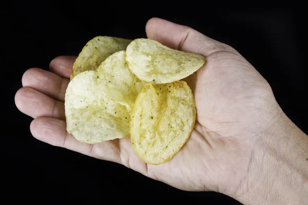 Hand met aardappel chips — Stockfoto