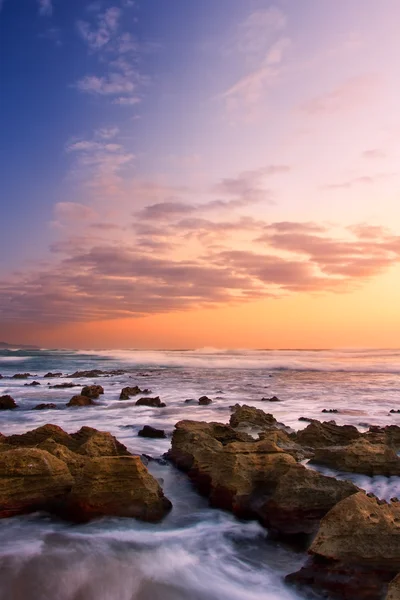 Alba paesaggio dell'oceano con onde nuvole e rocce — Foto Stock