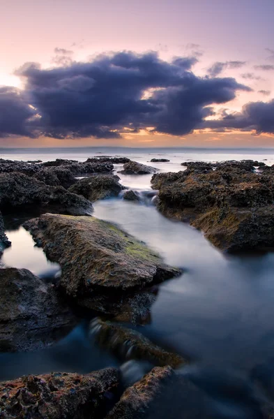 Alba paesaggio dell'oceano con onde nuvole e rocce — Foto Stock