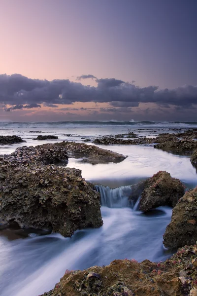 Nascer do sol paisagem do oceano com ondas nuvens e rochas — Fotografia de Stock