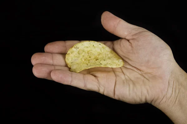 Hand holding one potato chip — Stock Photo, Image