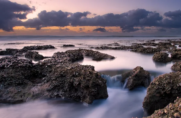 Alba paesaggio dell'oceano con onde nuvole e rocce — Foto Stock