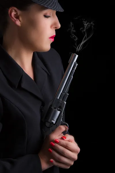 Gefährliche Frau in Schwarz mit silberner rauchender Handfeuerwaffe — Stockfoto