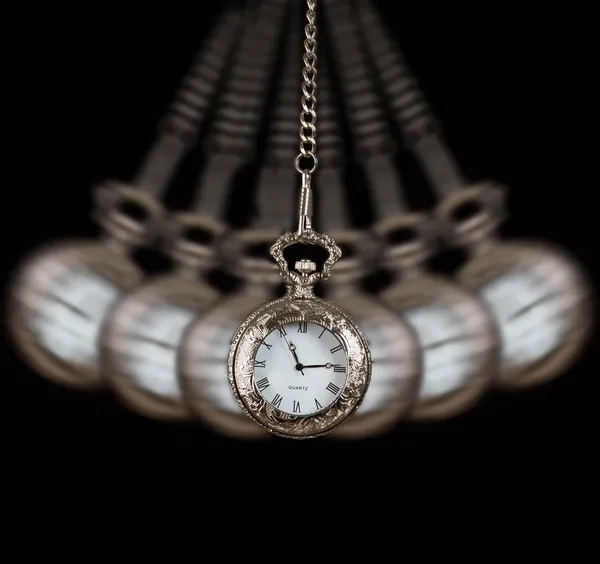 Pocket watch swinging on a chain black background — Stock Photo, Image