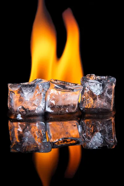 Eiswürfel mit Flamme auf glänzender schwarzer Oberfläche — Stockfoto