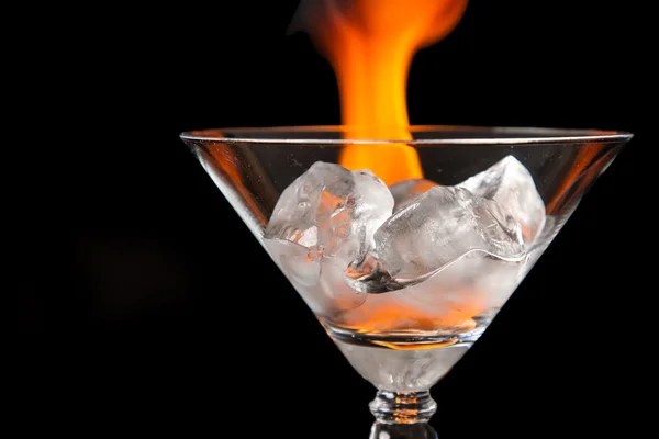 Ice cubes in glass with flame on shiny black surface — Stock Photo, Image